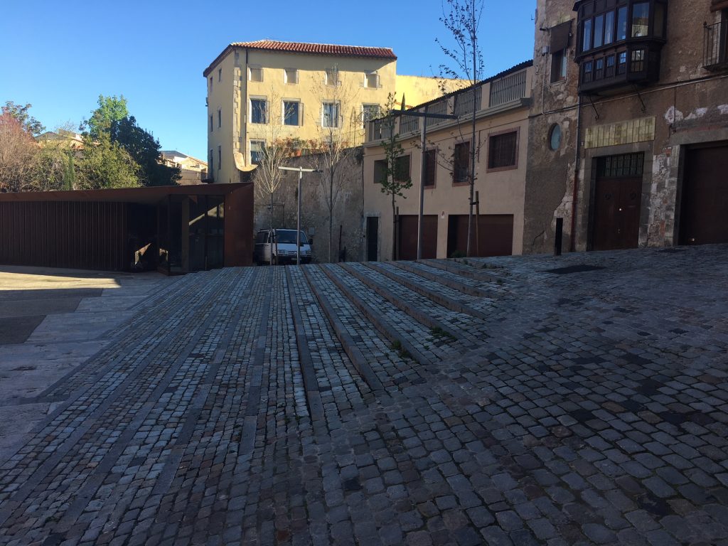 Pavimentación con adoquín recuperado y creación de tiras de pavimento con piedra de Girona